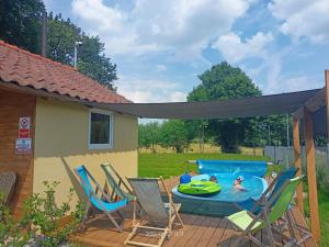a patio with chairs and a pool with a canopy at Cicha Dolina in Wydminy