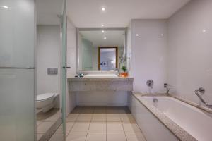 un bagno con vasca, WC e lavandino di Agamim by Isrotel Collection a Eilat
