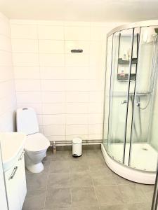 uma casa de banho com um chuveiro e um WC. em 3 rooms with private kitchen & private bathroom 5B em Gävle