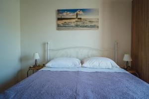 賽蓋然基卡的住宿－Seaside Apartments，一张带两个枕头的床和一张墙上的照片