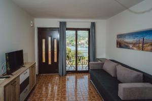 ein Wohnzimmer mit einem Sofa und einem TV in der Unterkunft Seaside Apartments in Seget Vranjica