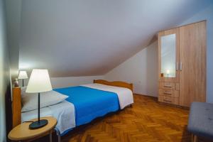 een slaapkamer met een bed, een dressoir en een lamp bij Seaside Apartments in Seget Vranjica
