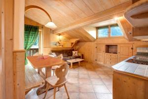 Una gran cocina con techo de madera y una mesa. en Appartamento Castagno Chalet Cambra, en Livigno