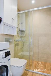 a bathroom with a toilet and a glass shower at White Forest in Juodkrantė