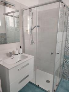 a white bathroom with a shower and a sink at La Veranda in Pachino