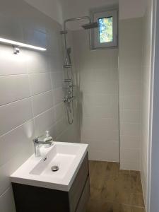 a white bathroom with a sink and a shower at Mark Apartman in Balatonszárszó +15 photos