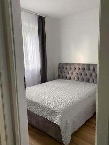 a bedroom with a bed in a room with a window at Mark Apartman in Balatonszárszó