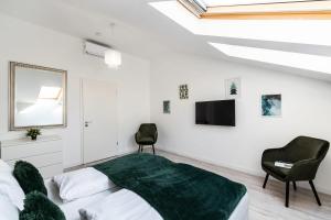 Schlafzimmer mit einem Bett, einem TV und einem Stuhl in der Unterkunft Quiet very central & stylish apt in Budapest