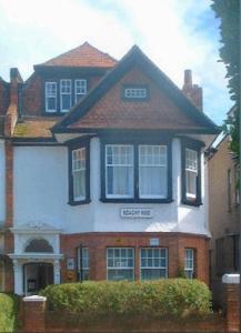 een groot bakstenen huis met zwart en wit bij Beachy Rise in Eastbourne