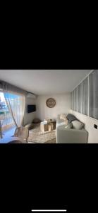 uma sala de estar com um sofá branco e uma janela em MAGNIFIQUE T2 AVEC PISCINE - CENTRE SAINTE MAXIME em Sainte-Maxime