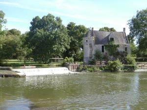 una casa vieja a un lado de un lago en Charmante Maison dans petite citée de caractère 13km du ZOO, en Luché-Pringé