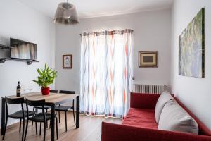 a living room with a red couch and a table at Agriturismo Tenuta La Meridiana in Montegrosso dʼAsti