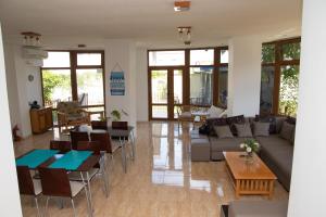 a living room with a couch and tables and chairs at Vila Nautica in Costinesti