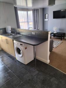 a kitchen with a washing machine under a counter at Place by the sea 2 in Bridlington +7 photos