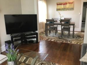 a living room with a flat screen tv and a table at Cherry Street Vintage Apartment-Free Parking! in Tulsa