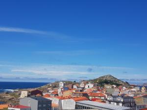 un grupo de edificios en una colina junto al océano en Piso en Muxía con magníficas vistas al mar, en Muxía