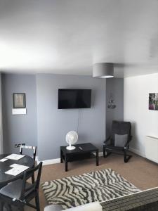 a living room with a couch and a television on a wall at Place by the sea 2 in Bridlington