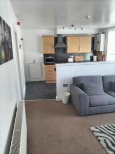 a living room with a couch and a kitchen at Place by the sea 2 in Bridlington
