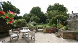 a patio with two chairs and a table in a garden at Beachy Rise in Eastbourne