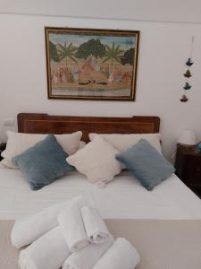1 cama blanca con almohadas y una foto en la pared en Sea and Tradition b&b, en Monopoli