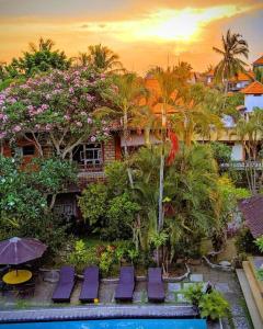 a resort with a pool and purple chairs and trees at Okawati Boutique Bungalows in Ubud