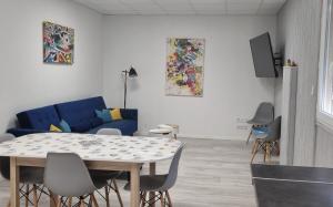 ein Wohnzimmer mit einem Tisch und einem blauen Sofa in der Unterkunft Modernité et élégance - Appartement - WIFI in Issoire