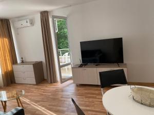 A television and/or entertainment centre at Amel -new luxury apartment close to the beach