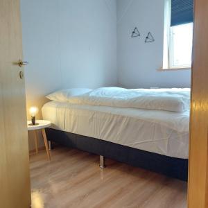 a bedroom with a bed and a table and a window at H3 apartment - cozy downtown apartment in Akureyri