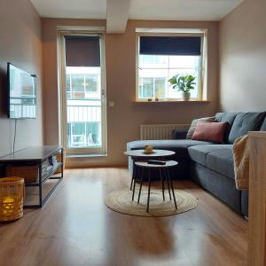 uma sala de estar com um sofá e uma mesa em H3 apartment - cozy downtown apartment em Akureyri