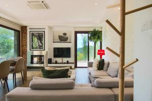 a living room with two couches and a tv at Phaedrus Living: Forest View Luxury Villa Chantara in Phini