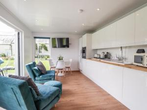 a kitchen and living room with white cabinets at Moss of Bourach in Aberlour