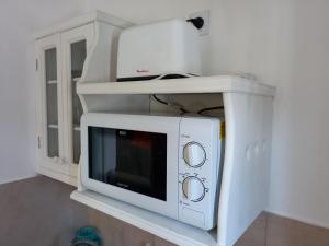 un microondas sentado en un estante en una cocina en Kay Pacha en Tilcara
