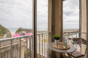een balkon met een tafel en uitzicht op het strand bij Au port de Binic - Loggia Vue mer - 50m de la plage in Binic