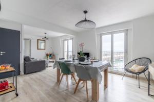 een eetkamer en een woonkamer met een tafel en stoelen bij Au port de Binic - Loggia Vue mer - 50m de la plage in Binic