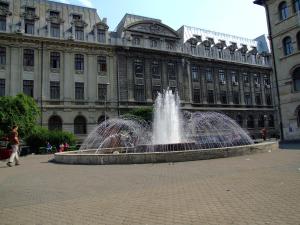 a water fountain in front of a large building at Old Town Studio by MRG Apartments in Bucharest