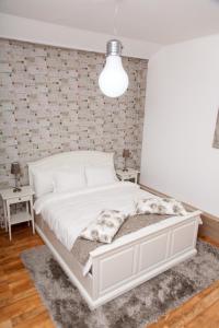 a white bed in a bedroom with a brick wall at Old Town Studio by MRG Apartments in Bucharest