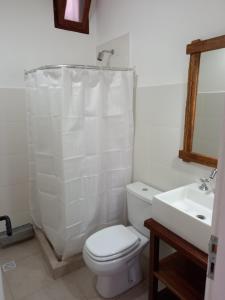 Baño blanco con aseo y lavamanos en Kay Pacha en Tilcara