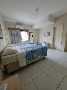 1 dormitorio con 1 cama y TV en Klein Ville Esteio Centro in 