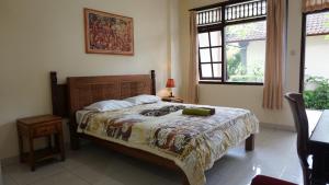 - une chambre avec un lit et une couverture dans l'établissement Nyuh Gading Accommodation Ubud, à Ubud
