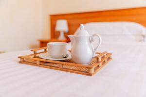 a tray with a tea pot and a cup on a bed at Mediterraneo B&B in Pizzo