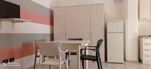 a kitchen with a table with chairs and a refrigerator at Corte nel borgo in Minervino di Lecce