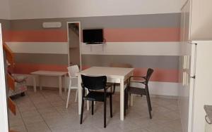 una sala da pranzo con tavolo e sedie bianchi di Corte nel borgo a Minervino di Lecce