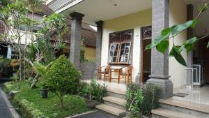 - une terrasse couverte à l'avant d'une maison avec une table et des chaises dans l'établissement Nyuh Gading Accommodation Ubud, à Ubud