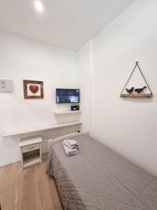 - une chambre avec un lit et une télévision murale dans l'établissement BMP APARTMENT EDELWEISS PASSO DEL TONALE, à Passo del Tonale