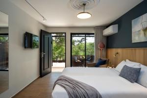 KeshetにあるKeshet Yehonatan Country Lodgingのベッドルーム1室(ベッド1台付)、スライド式ガラスドアが備わります。