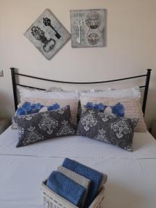 a bed with pillows and a blue towel on it at Tra Vento e Mare in Lendinuso