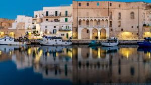 a group of boats in the water in front of buildings at Nial House in Monopoli