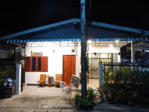 a house with a blue awning and a patio at Space Ben Guest House @ Muangkao in Sukhothai