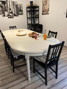 - une table à manger avec des chaises et une table blanche dans l'établissement Chambre double indépendante HARMONIE au sein du domaine PASSELOUP, à Liergues