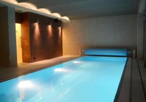 einen Pool mit blauen Lichtern im Bad in der Unterkunft Peras Wellness Hotel in Ludvíkov
